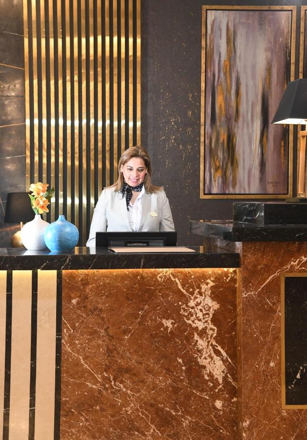 Tolip Gardens Hotel Kairo Exteriör bild A hotel receptionist at the front desk